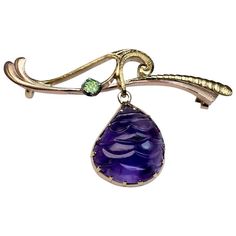 made in Moscow between 1899 and 1908 The 14K gold brooch is designed as a stylized branch with a hanging bezel-set amethyst and accented with a green demantoid garnet. The amethyst is carved to resemble a berry. An interesting and unusual brooch from Art Nouveau era. Marked on frame and pin with 56 zolotnik old Russian gold standard with initials of assay master Ivan Lebedkin and maker's initials 'MB'. Width 45 mm (1 3/4 in.) Antique Amethyst Jewelry, Demantoid Garnet, Gold Brooch, Antique Brooches, Pin Art, Art Nouveau Jewelry, Tie Pin, Couture Jewelry, Gold Brooches