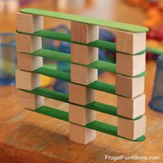 a wooden block tower made out of wood blocks on a table with toys in the background