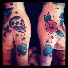 two hands with tattoos on their fingers and one has a skull, flower and cross