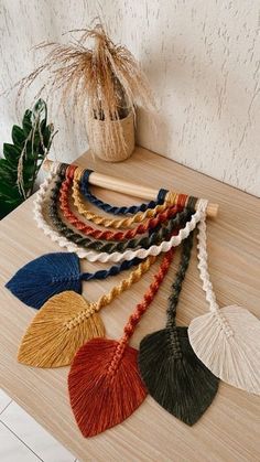 six tassels on a table next to a potted plant and a vase