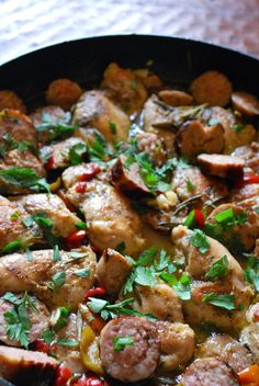 a skillet filled with meat and vegetables on top of a table