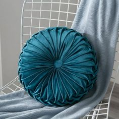 a blue pillow sitting on top of a white chair