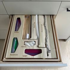 an open drawer with different colored glass items in it