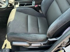 the interior of a car with black leather and gray cloth upholstered seat covers