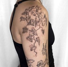 a woman's arm with flowers and vines on the left side of her body