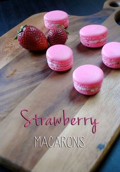 strawberry macaroons on a cutting board with strawberries