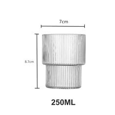 a glass vase sitting on top of a white table next to a measuring line with measurements