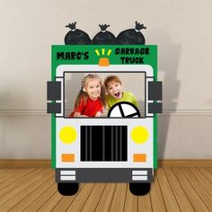 a green bus with two children in the front and on the back that says marc's garage truck