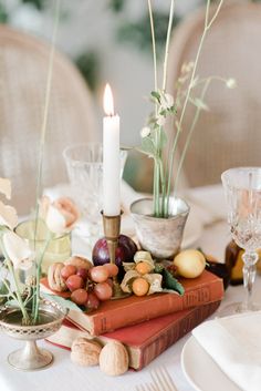 the table is set with books, candles and other things to decorate it for dinner