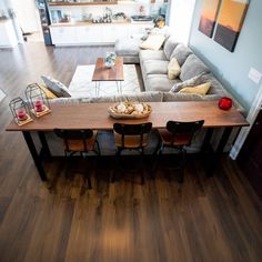 an overhead view of a living room and dining area with couches, coffee table, and kitchen in the background