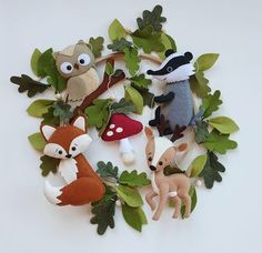 several stuffed animals are arranged in a circle on top of leaves and branches with eyes