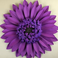 a purple paper flower is shown on the wall