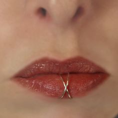 a woman's lips and nose are shown with the ring on top of her lip