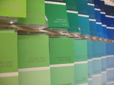 several shades of green and blue are on display in the store's paint colors