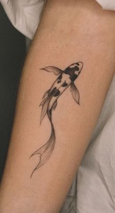 a black and white koi fish tattoo on the arm