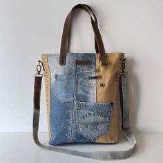 a handbag made out of old jeans and leather with an embellishment on the side