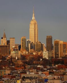 the empire state building towering over new york's city skyline is seen in this photograph