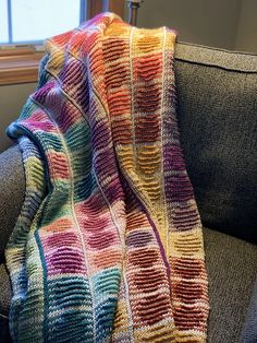 a multicolored blanket sitting on top of a couch