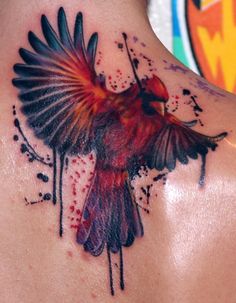 a bird tattoo on the back of a man's neck