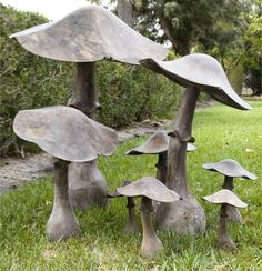 a group of metal mushrooms sitting in the grass