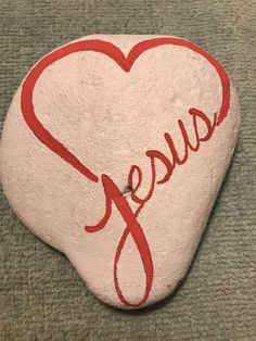 a rock with the word jesus painted on it and a red heart in the middle