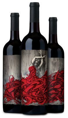 three bottles of red wine with an artistic painting on them