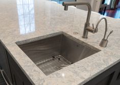 a kitchen sink sitting under a faucet next to a counter top in a home