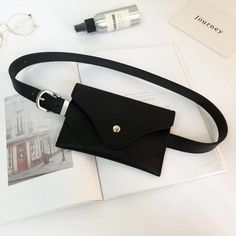 a black belt bag sitting on top of a table next to an eyeglass case