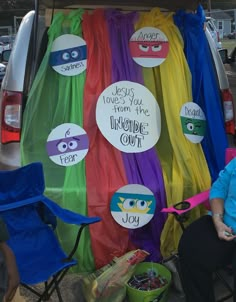 a woman sitting in a chair next to a van with some decorations on the back