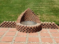 a fire pit made out of bricks in the grass