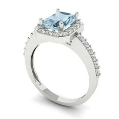 a blue topazte and diamond ring on a white background with the center stone surrounded by smaller diamonds