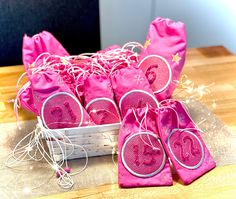 some pink bags with white string on top of a wooden table