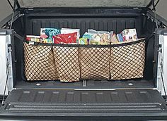 the back end of a white truck filled with books and bags in it's trunk