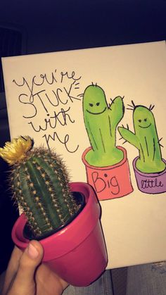 a cactus in a pink pot next to a hand holding a card that says you're stuck with me