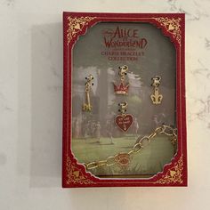 a red and gold necklace with charms in the shape of hearts is hanging on a wall