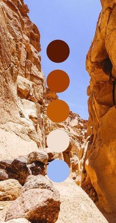 an image of some rocks with circles hanging from them in the middle of it's landscape