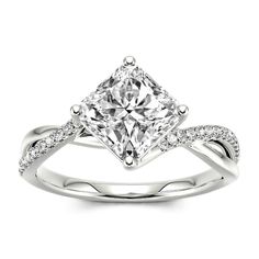 a white gold ring with a princess cut diamond in the center and pave set shoulders