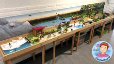 there is a long table with many toys on it and a large mural behind it