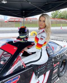 a woman sitting on top of a racing car