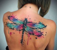 the back of a woman's shoulder with a dragonfly tattoo on it, painted in