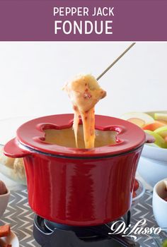 a red fondue pot with cheese being lifted from it