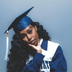 a woman wearing a cap and gown posing for a photo with her hand on her chin