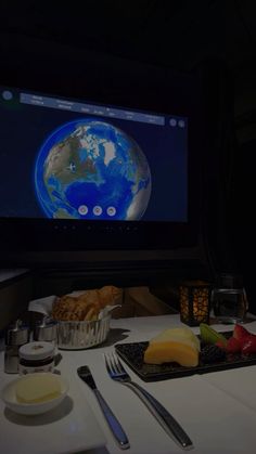 a table topped with plates and bowls filled with food next to a flat screen tv