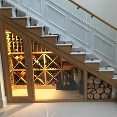 the stairs are made of wood and have wine racks on each side with glass doors