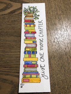 a bookmark with books stacked on top of each other and the words, one that reads