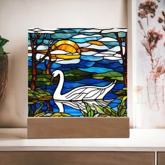 a stained glass swan sitting on top of a shelf