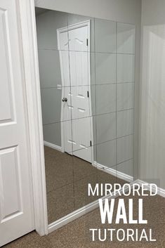 a mirror sitting in the middle of a room next to a white door and window