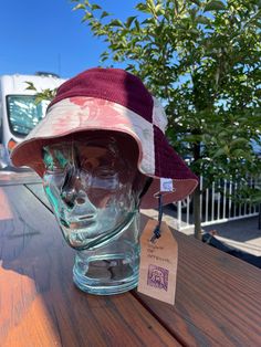 a hat is sitting on top of a glass head mannequin's head