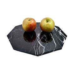 two apples sitting on top of a black marble table