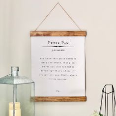 a sign hanging on the wall next to a candle and vase with flowers in it